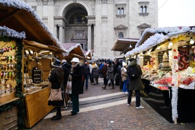 Tourists in Christmas market outside St. Stephen Basilica in Budapest, Hungary on December 21, 2022.