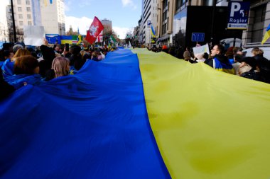 Supporters of Ukraine unfurl a giant flag during a demonstration for the first anniversary of the Russian invasion in Brussels, Belgium on Feb. 25, 2023.