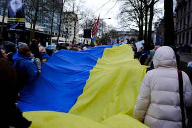 Supporters of Ukraine unfurl a giant flag during a demonstration for the first anniversary of the Russian invasion in Brussels, Belgium on Feb. 25, 2023.