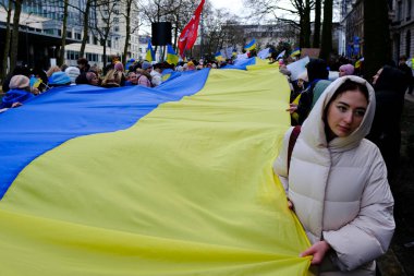 Supporters of Ukraine unfurl a giant flag during a demonstration for the first anniversary of the Russian invasion in Brussels, Belgium on Feb. 25, 2023.