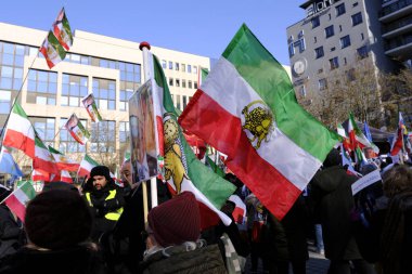 Demonstrators hold the pre-Islamic 1979 Revolution flag as they takes part during a protest supporting Iranian resistance movement in Brussels on March 1, 2023.