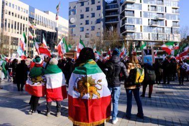 Demonstrators hold the pre-Islamic 1979 Revolution flag as they takes part during a protest supporting Iranian resistance movement in Brussels on March 1, 2023.