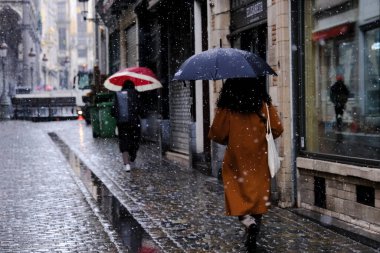 People walk during a snowfall in city of Brussels, Belgium on March 8, 2023 clipart