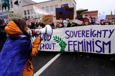 8 Mart 2023 'te Belçika' nın Brüksel kentinde düzenlenen Uluslararası Kadın Günü münasebetiyle düzenlenen mitingde aktivistler pankart ve slogan tutuyorlar..