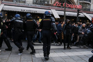 Fransa 'nın orta kesimindeki Paris' te 6 Nisan 2023 'te hükümetin emeklilik sistemini yenileme planlarına karşı düzenlenen ulusal bir grev sırasında, çevik kuvvet polisi protestocularla çatışmaya girdi..