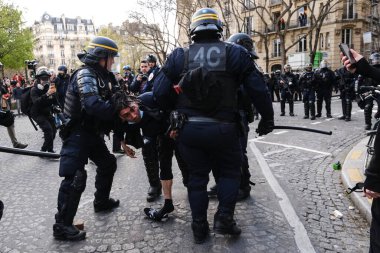 Fransa 'nın orta kesimindeki Paris' te 6 Nisan 2023 'te hükümetin emeklilik sistemini yenileme planlarına karşı düzenlenen ulusal bir grev sırasında, çevik kuvvet polisi protestocularla çatışmaya girdi..