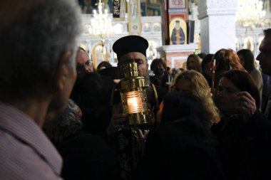 Bir Ortodoks rahibi, 15 Nisan 2023 'te Atina' daki Aziz George Kilisesi 'nde Kudüs' ten getirilen kutsal ateşle birlikte bir kazan taşıyor..