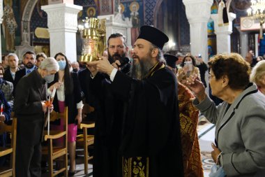 Bir Ortodoks rahibi, 15 Nisan 2023 'te Atina' daki Aziz George Kilisesi 'nde Kudüs' ten getirilen kutsal ateşle birlikte bir kazan taşıyor..