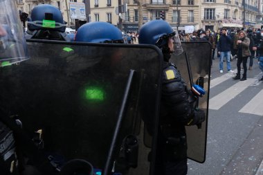 Fransa 'nın orta kesimindeki Paris' te 6 Nisan 2023 'te hükümetin emeklilik sistemini yenileme planlarına karşı düzenlenen ulusal bir grev sırasında, çevik kuvvet polisi protestocularla çatışmaya girdi..