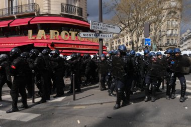 Fransa 'nın orta kesimindeki Paris' te 6 Nisan 2023 'te hükümetin emeklilik sistemini yenileme planlarına karşı düzenlenen ulusal bir grev sırasında, çevik kuvvet polisi protestocularla çatışmaya girdi..