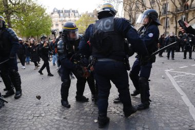 Fransa 'nın orta kesimindeki Paris' te 6 Nisan 2023 'te hükümetin emeklilik sistemini yenileme planlarına karşı düzenlenen ulusal bir grev sırasında, çevik kuvvet polisi protestocularla çatışmaya girdi..