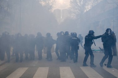 Fransa 'nın orta kesimindeki Paris' te 6 Nisan 2023 'te hükümetin emeklilik sistemini yenileme planlarına karşı düzenlenen ulusal bir grev sırasında, çevik kuvvet polisi protestocularla çatışmaya girdi..