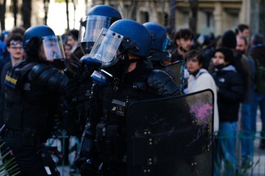 Fransa 'nın orta kesimindeki Paris' te 6 Nisan 2023 'te hükümetin emeklilik sistemini yenileme planlarına karşı düzenlenen ulusal bir grev sırasında, çevik kuvvet polisi protestocularla çatışmaya girdi..