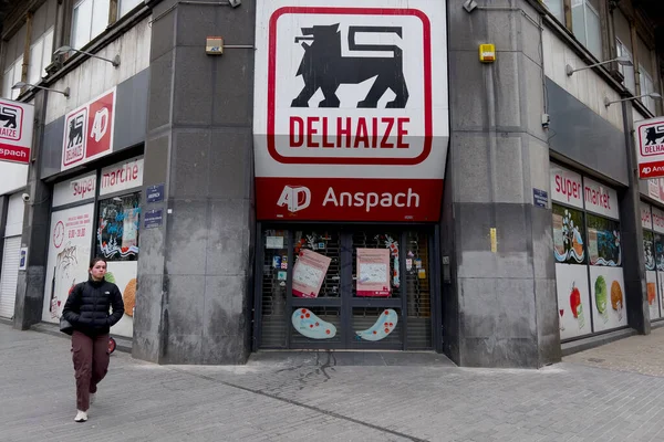 人々は4月にベルギーのブリュッセルで閉鎖されたDelhaizeスーパーマーケットの外を歩く 2023年7月27日 — ストック写真