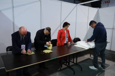 Belçika 'nın Brüksel kentindeki bir sandık merkezinde 29 Nisan 2023' te yapılan Türkiye Cumhurbaşkanlığı ve Genel Seçimleri sırasında bir seçim görevlisi oy pusulalarını hazırlıyor..