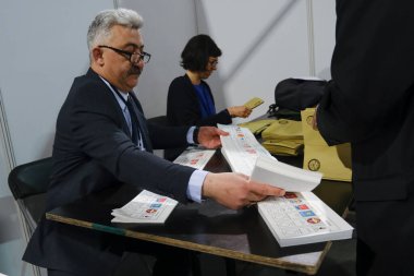 Belçika 'nın Brüksel kentindeki bir sandık merkezinde 29 Nisan 2023' te yapılan Türkiye Cumhurbaşkanlığı ve Genel Seçimleri sırasında bir seçim görevlisi oy pusulalarını hazırlıyor..
