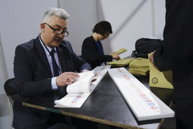 Belçika 'nın Brüksel kentindeki bir sandık merkezinde 29 Nisan 2023' te yapılan Türkiye Cumhurbaşkanlığı ve Genel Seçimleri sırasında bir seçim görevlisi oy pusulalarını hazırlıyor..