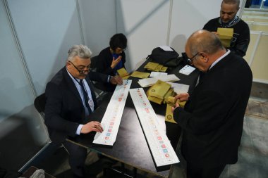 Belçika 'nın Brüksel kentindeki bir sandık merkezinde 29 Nisan 2023' te yapılan Türkiye Cumhurbaşkanlığı ve Genel Seçimleri sırasında bir seçim görevlisi oy pusulalarını hazırlıyor..