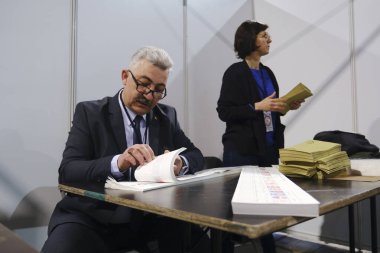 Belçika 'nın Brüksel kentindeki bir sandık merkezinde 29 Nisan 2023' te yapılan Türkiye Cumhurbaşkanlığı ve Genel Seçimleri sırasında bir seçim görevlisi oy pusulalarını hazırlıyor..