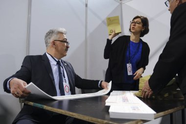 Belçika 'nın Brüksel kentindeki bir sandık merkezinde 29 Nisan 2023' te yapılan Türkiye Cumhurbaşkanlığı ve Genel Seçimleri sırasında bir seçim görevlisi oy pusulalarını hazırlıyor..