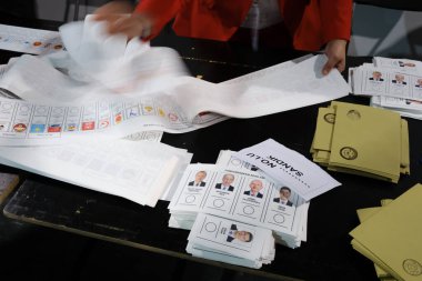 Belçika 'nın Brüksel kentindeki bir sandık merkezinde 29 Nisan 2023' te yapılan Türkiye Cumhurbaşkanlığı ve Genel Seçimleri sırasında bir seçim görevlisi oy pusulalarını hazırlıyor..