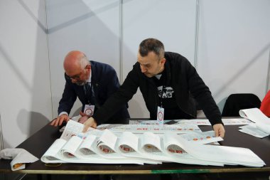 Belçika 'nın Brüksel kentindeki bir sandık merkezinde 29 Nisan 2023' te yapılan Türkiye Cumhurbaşkanlığı ve Genel Seçimleri sırasında bir seçim görevlisi oy pusulalarını hazırlıyor..