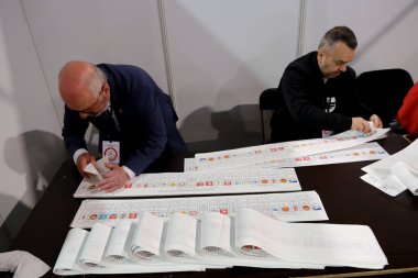Belçika 'nın Brüksel kentindeki bir sandık merkezinde 29 Nisan 2023' te yapılan Türkiye Cumhurbaşkanlığı ve Genel Seçimleri sırasında bir seçim görevlisi oy pusulalarını hazırlıyor..