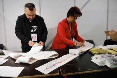 Belçika 'nın Brüksel kentindeki bir sandık merkezinde 29 Nisan 2023' te yapılan Türkiye Cumhurbaşkanlığı ve Genel Seçimleri sırasında bir seçim görevlisi oy pusulalarını hazırlıyor..