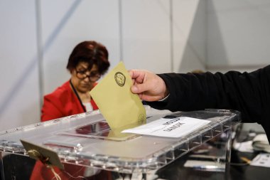 29 Nisan 2023 'te Brüksel, Belçika' daki bir sandık merkezinde yapılan Türkiye Cumhurbaşkanlığı ve Genel Seçimleri sırasında oy kullanan bir seçmen görülüyor..