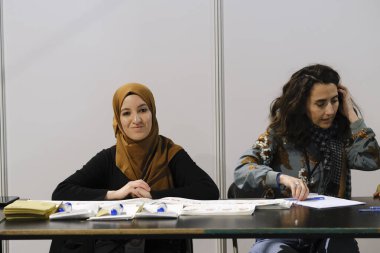 Belçika 'nın Brüksel kentindeki bir sandık merkezinde 29 Nisan 2023' te yapılan Türkiye Cumhurbaşkanlığı ve Genel Seçimleri sırasında bir seçim görevlisi oy pusulalarını hazırlıyor..