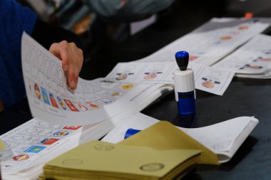 Belçika 'nın Brüksel kentindeki bir sandık merkezinde 29 Nisan 2023' te yapılan Türkiye Cumhurbaşkanlığı ve Genel Seçimleri sırasında bir seçim görevlisi oy pusulalarını hazırlıyor..