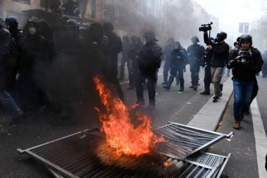 Maskeli protestocular, 6 Nisan 2023 'te Fransa' nın Paris kentinde düzenlenen bir gösteride meydana gelen çatışmalar sırasında çöp bidonları ve motosikletleri ateşe verdiler..