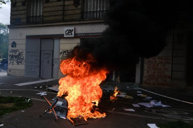 Maskeli protestocular, 6 Nisan 2023 'te Fransa' nın Paris kentinde düzenlenen bir gösteride meydana gelen çatışmalar sırasında çöp bidonları ve motosikletleri ateşe verdiler..