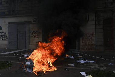 Maskeli protestocular, 6 Nisan 2023 'te Fransa' nın Paris kentinde düzenlenen bir gösteride meydana gelen çatışmalar sırasında çöp bidonları ve motosikletleri ateşe verdiler..