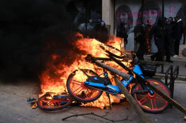 Maskeli protestocular, 6 Nisan 2023 'te Fransa' nın Paris kentinde düzenlenen bir gösteride meydana gelen çatışmalar sırasında çöp bidonları ve motosikletleri ateşe verdiler..