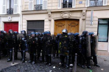 Fransız CRS toplum polisi, 1 Mayıs 2023 'te Paris, Fransa' da düzenlenen geleneksel 1 Mayıs çalışma yürüyüşü, Fransız emeklilik reform yasası ve sosyal adalet için seferberlik gününde nöbet tutuyor..