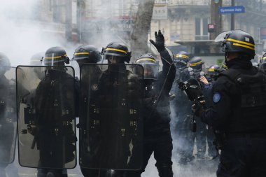 Fransız CRS toplum polisi, 1 Mayıs 2023 'te Paris, Fransa' da düzenlenen geleneksel 1 Mayıs çalışma yürüyüşü, Fransız emeklilik reform yasası ve sosyal adalet için seferberlik gününde nöbet tutuyor..