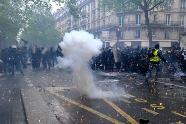 Çevik kuvvet, 1 Mayıs 2023 'te Paris, Fransa' da Fransız emeklilik reform yasasına ve sosyal adalete karşı yapılan seferberlik yürüyüşü sırasında kalabalığı dağıtmak için göz yaşartıcı gaz kullandı..