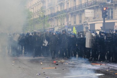 Çevik kuvvet, 1 Mayıs 2023 'te Paris, Fransa' da Fransız emeklilik reform yasasına ve sosyal adalete karşı yapılan seferberlik yürüyüşü sırasında kalabalığı dağıtmak için göz yaşartıcı gaz kullandı..