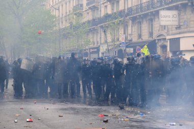 Çevik kuvvet, 1 Mayıs 2023 'te Paris, Fransa' da Fransız emeklilik reform yasasına ve sosyal adalete karşı yapılan seferberlik yürüyüşü sırasında kalabalığı dağıtmak için göz yaşartıcı gaz kullandı..