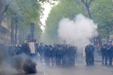 Çevik kuvvet, 1 Mayıs 2023 'te Paris, Fransa' da Fransız emeklilik reform yasasına ve sosyal adalete karşı yapılan seferberlik yürüyüşü sırasında kalabalığı dağıtmak için göz yaşartıcı gaz kullandı..