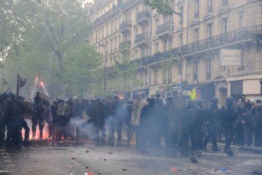 Çevik kuvvet, 1 Mayıs 2023 'te Paris, Fransa' da Fransız emeklilik reform yasasına ve sosyal adalete karşı yapılan seferberlik yürüyüşü sırasında kalabalığı dağıtmak için göz yaşartıcı gaz kullandı..