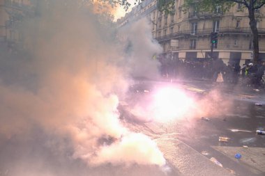 Çevik kuvvet, 1 Mayıs 2023 'te Paris, Fransa' da Fransız emeklilik reform yasasına ve sosyal adalete karşı yapılan seferberlik yürüyüşü sırasında kalabalığı dağıtmak için göz yaşartıcı gaz kullandı..
