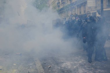 Çevik kuvvet, 1 Mayıs 2023 'te Paris, Fransa' da Fransız emeklilik reform yasasına ve sosyal adalete karşı yapılan seferberlik yürüyüşü sırasında kalabalığı dağıtmak için göz yaşartıcı gaz kullandı..