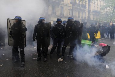 Çevik kuvvet, 1 Mayıs 2023 'te Paris, Fransa' da Fransız emeklilik reform yasasına ve sosyal adalete karşı yapılan seferberlik yürüyüşü sırasında kalabalığı dağıtmak için göz yaşartıcı gaz kullandı..