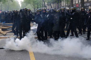 Çevik kuvvet, 1 Mayıs 2023 'te Paris, Fransa' da Fransız emeklilik reform yasasına ve sosyal adalete karşı yapılan seferberlik yürüyüşü sırasında kalabalığı dağıtmak için göz yaşartıcı gaz kullandı..