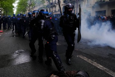Çevik kuvvet, 1 Mayıs 2023 'te Paris, Fransa' da Fransız emeklilik reform yasasına ve sosyal adalete karşı yapılan seferberlik yürüyüşü sırasında kalabalığı dağıtmak için göz yaşartıcı gaz kullandı..
