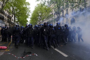 Çevik kuvvet, 1 Mayıs 2023 'te Paris, Fransa' da Fransız emeklilik reform yasasına ve sosyal adalete karşı yapılan seferberlik yürüyüşü sırasında kalabalığı dağıtmak için göz yaşartıcı gaz kullandı..