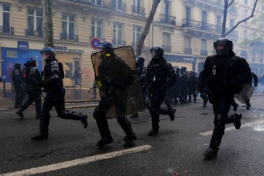 Çevik kuvvet, 1 Mayıs 2023 'te Paris, Fransa' da Fransız emeklilik reform yasasına ve sosyal adalete karşı yapılan seferberlik yürüyüşü sırasında kalabalığı dağıtmak için göz yaşartıcı gaz kullandı..