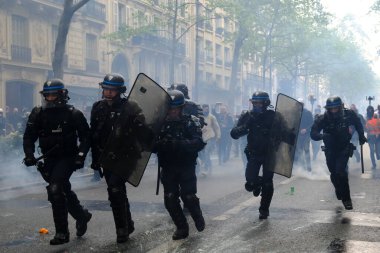 Çevik kuvvet, 1 Mayıs 2023 'te Paris, Fransa' da Fransız emeklilik reform yasasına ve sosyal adalete karşı yapılan seferberlik yürüyüşü sırasında kalabalığı dağıtmak için göz yaşartıcı gaz kullandı..